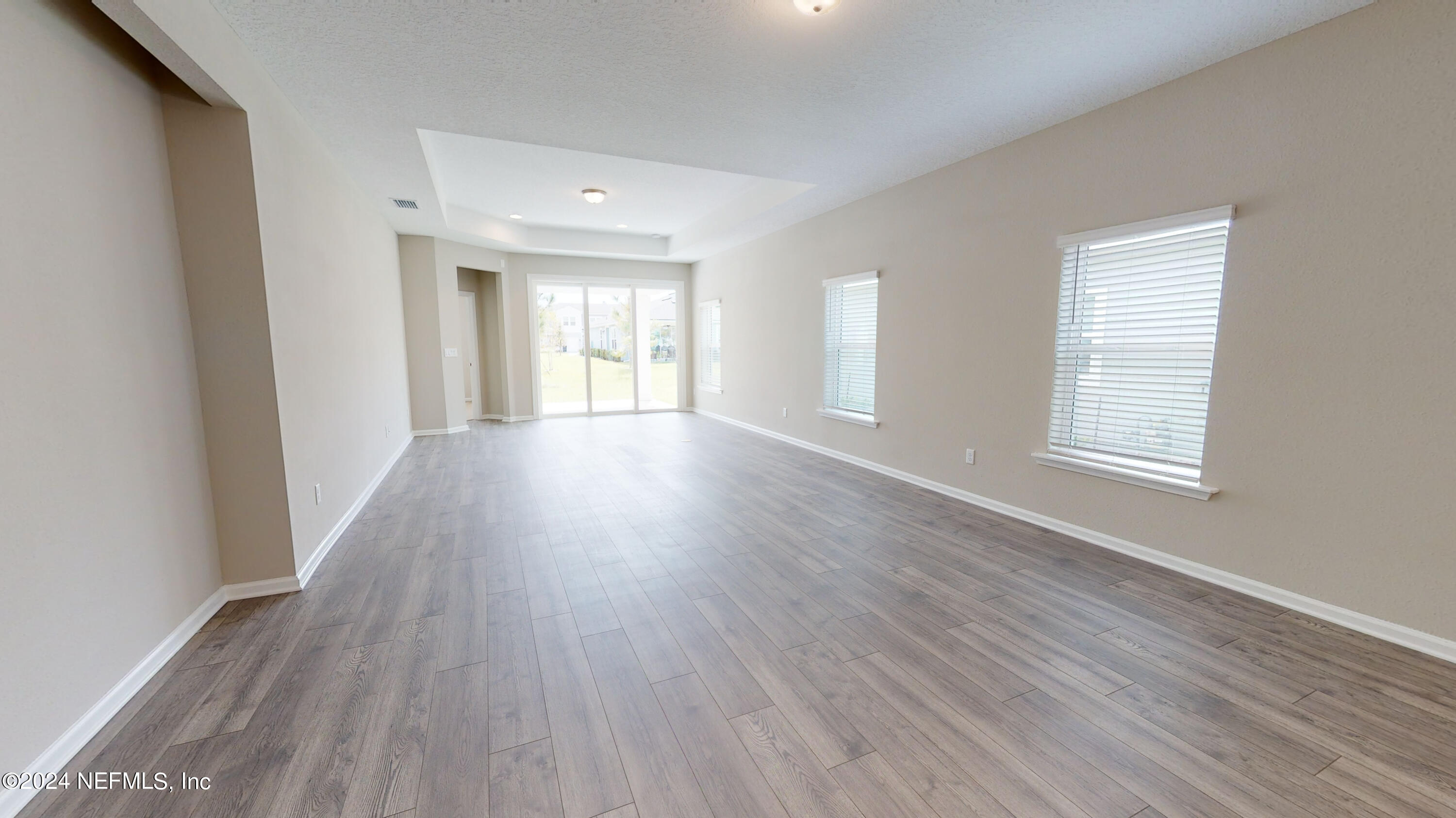 182 Holly Forest Drive St. Augustine, FL 32092 - Photo 13 of 29 an empty room with wooden floor and windows