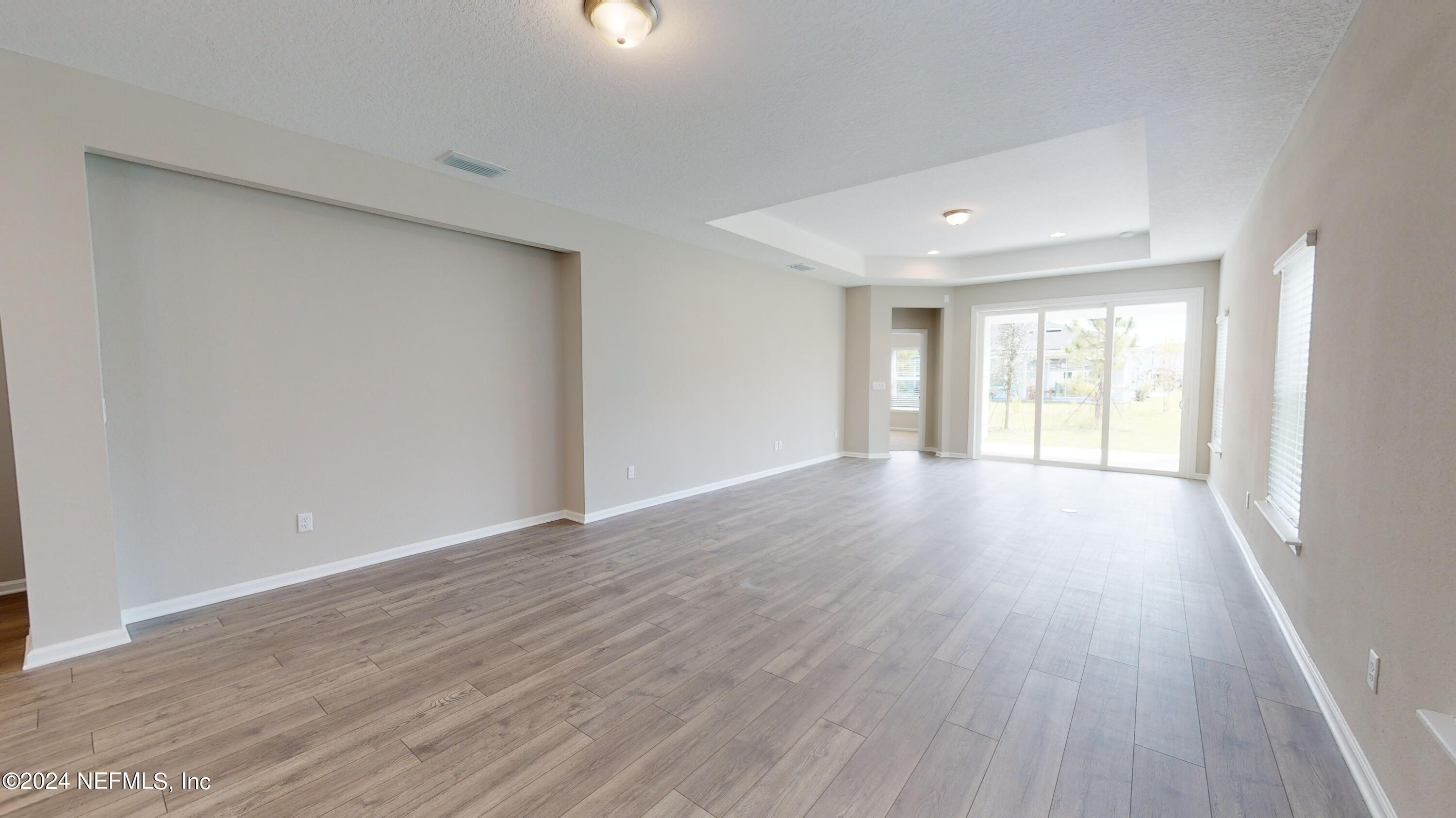 182 Holly Forest Drive St. Augustine, FL 32092 - Photo 17 of 29 a view of an empty room with wooden floor and a window