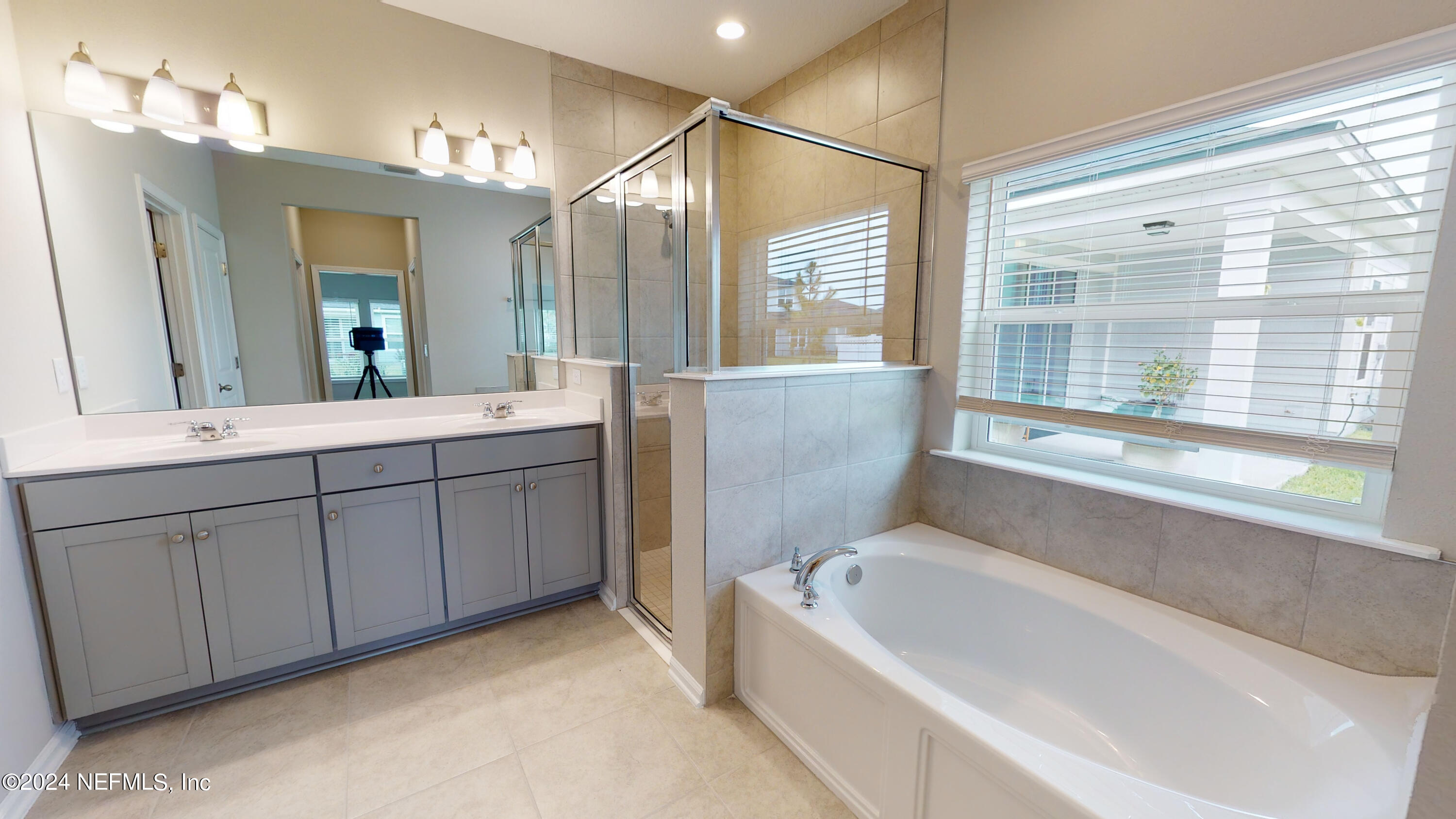 182 Holly Forest Drive St. Augustine, FL 32092 - Photo 24 of 29 a bathroom with a tub a sink and a large mirror