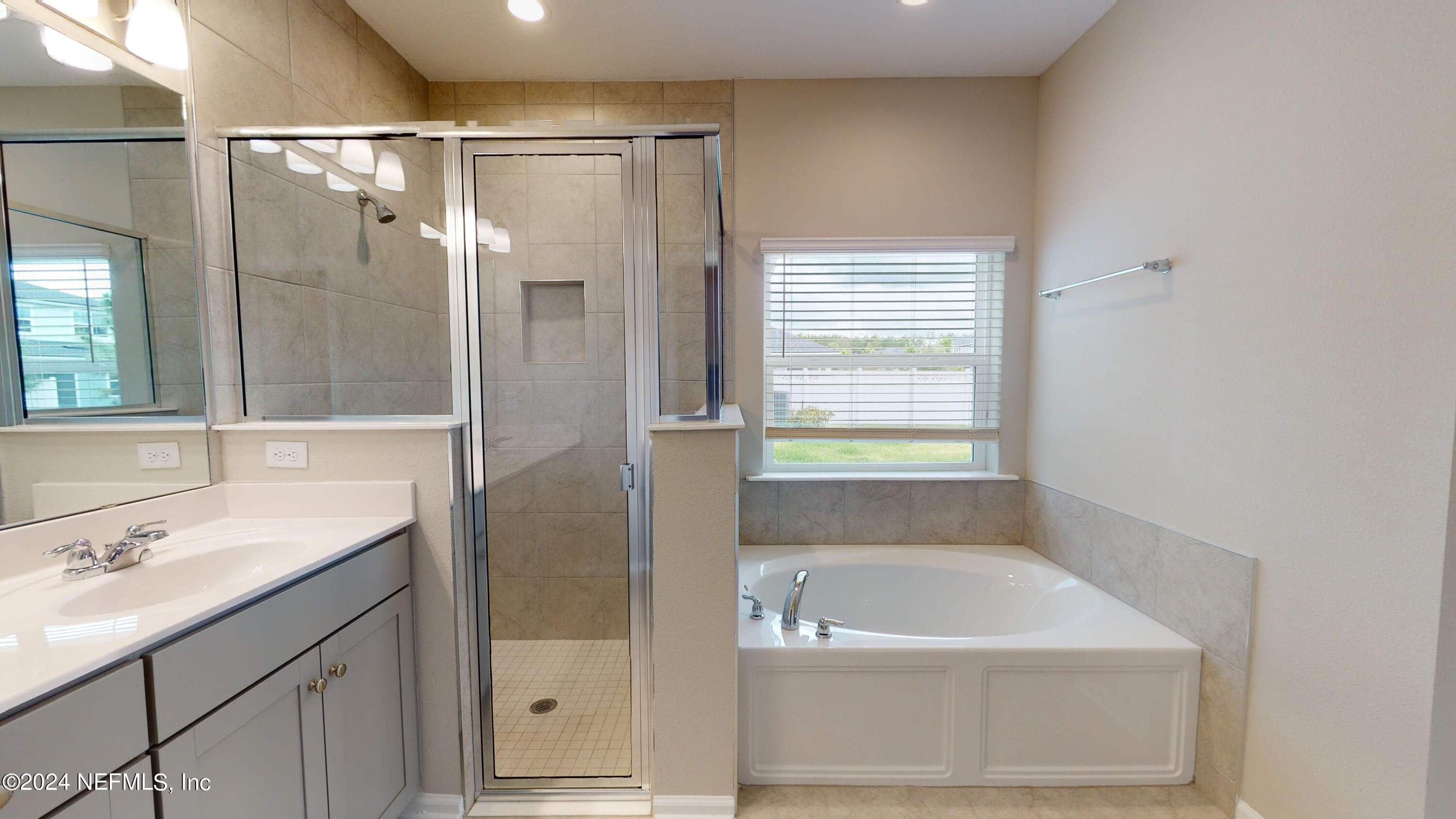 182 Holly Forest Drive St. Augustine, FL 32092 - Photo 25 of 29 a bathroom with a tub a sink shower and mirror
