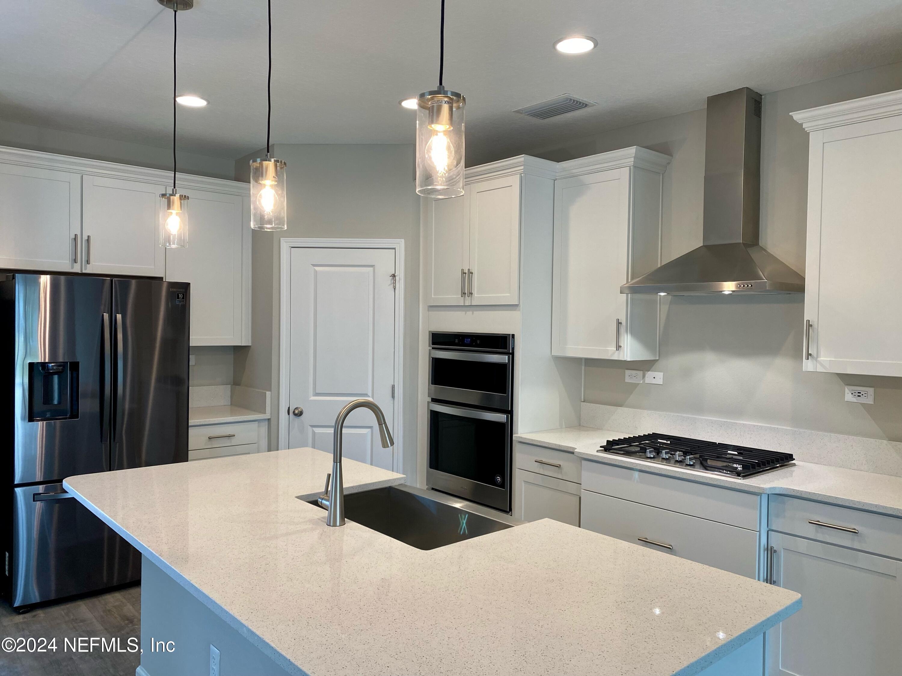 182 Holly Forest Drive St. Augustine, FL 32092 - Photo 6 of 29 a kitchen with stainless steel appliances granite countertop a sink a stove a refrigerator and island