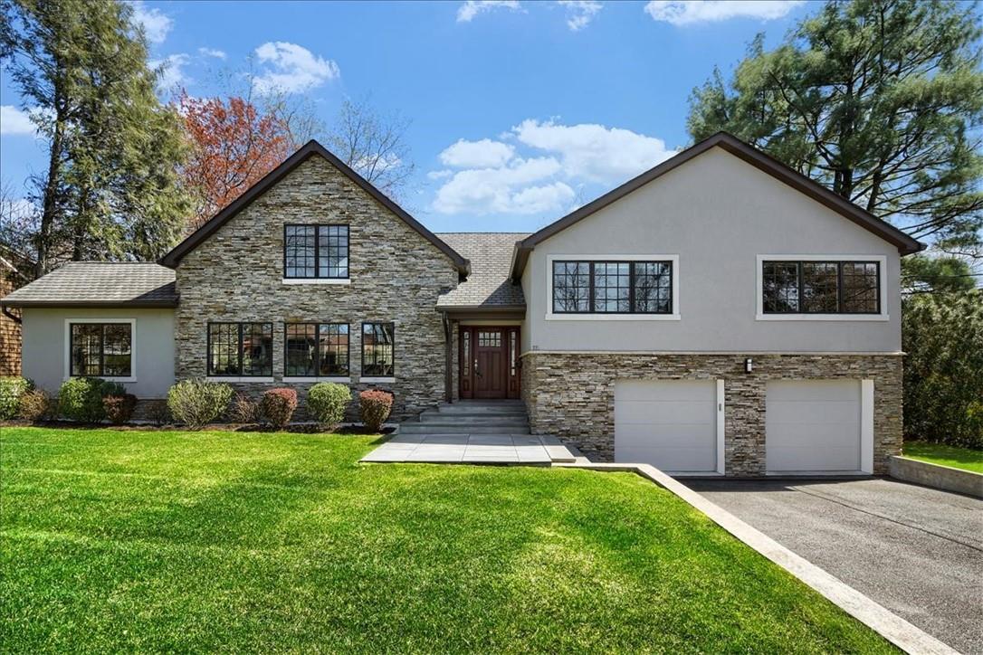 a front view of a house with a yard and garage