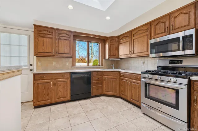 a kitchen with stainless steel appliances granite countertop a stove sink and microwave