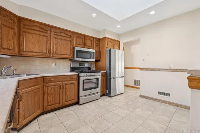 a kitchen with stainless steel appliances granite countertop a refrigerator sink and stove