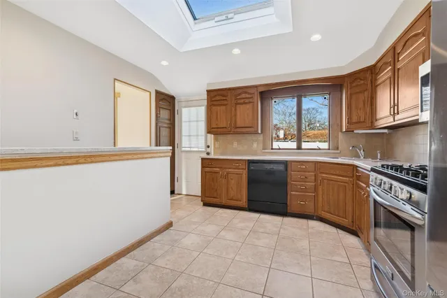 a kitchen with stainless steel appliances granite countertop a stove a sink and a refrigerator