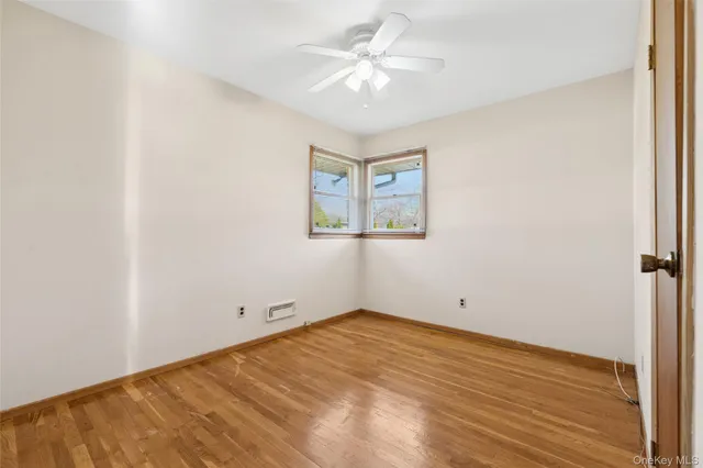 an empty room with a fan and a window