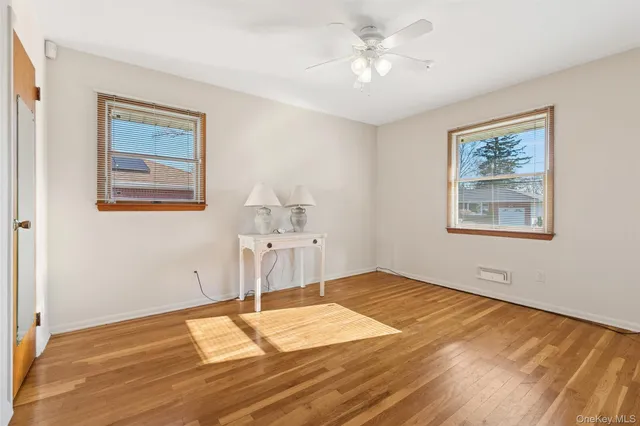 a view of a room with wooden floor and ceiling fan
