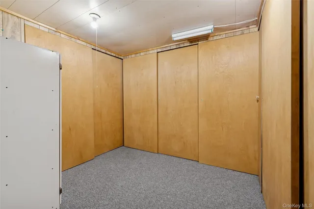 a view of a refrigerator in kitchen and an empty room