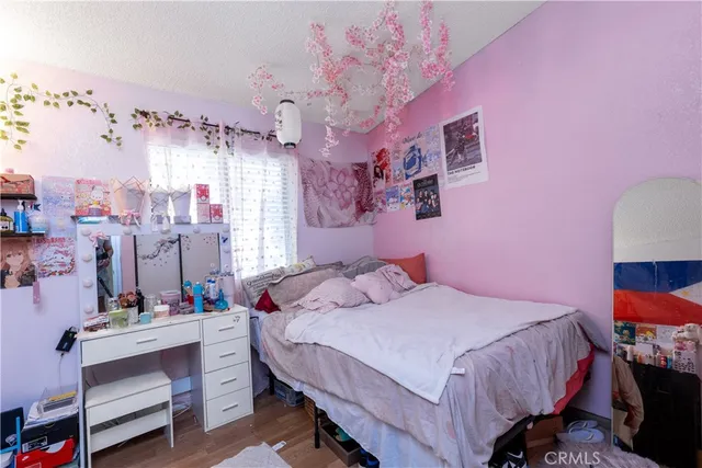 a bedroom with a bed a desk and chair with the large mirror