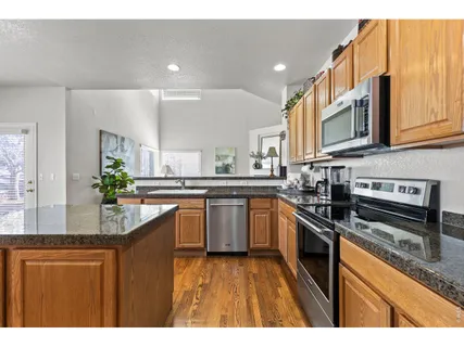 a kitchen with stainless steel appliances granite countertop a sink a stove and cabinets