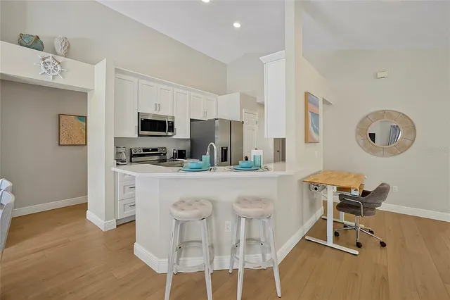 a kitchen with stainless steel appliances kitchen island granite countertop a stove a sink a microwave and refrigerator