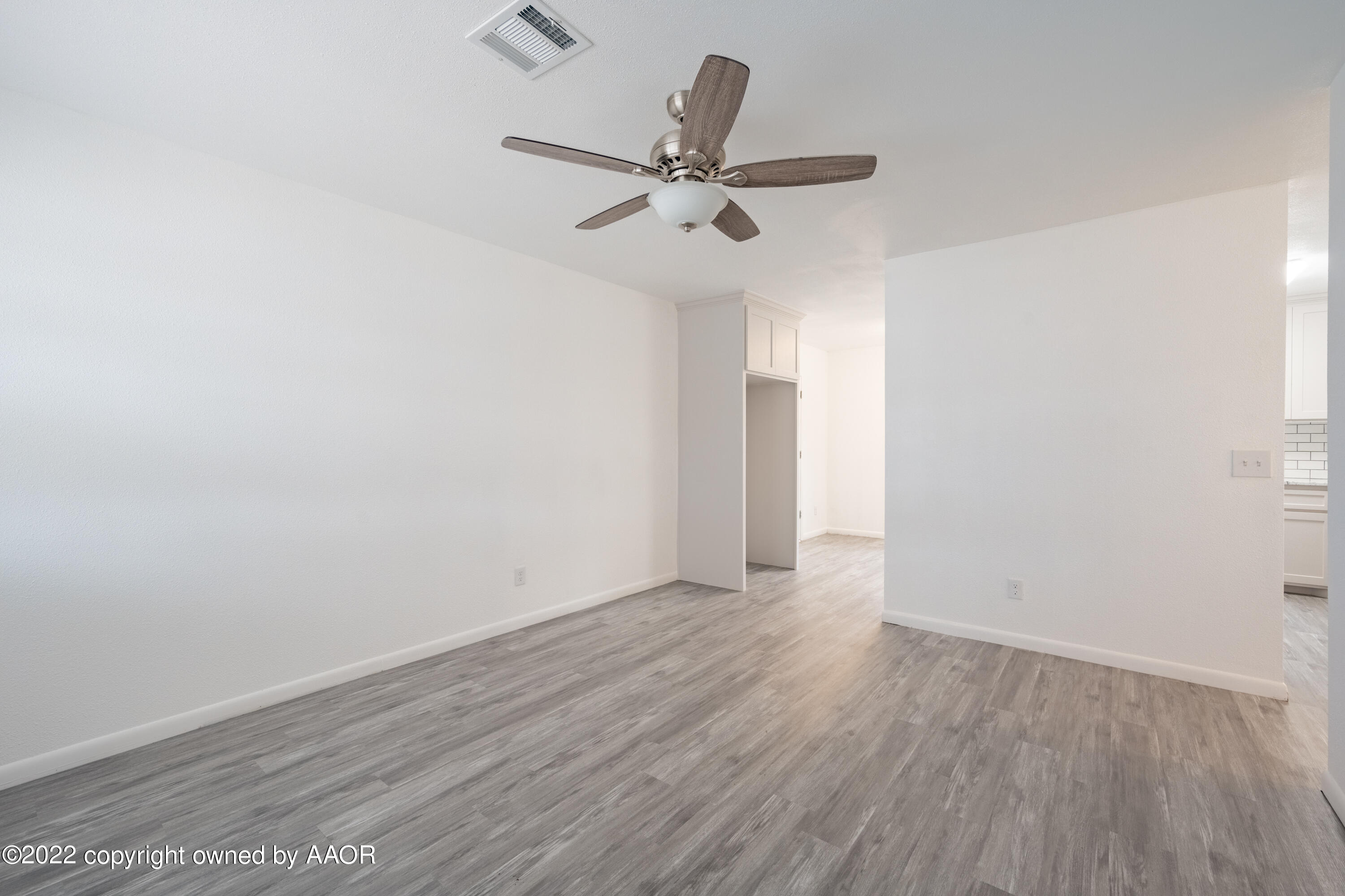 5311 Allen Street Amarillo, TX 79110 - Photo 6 of 22 a view of a room with wooden floor a ceiling fan and window