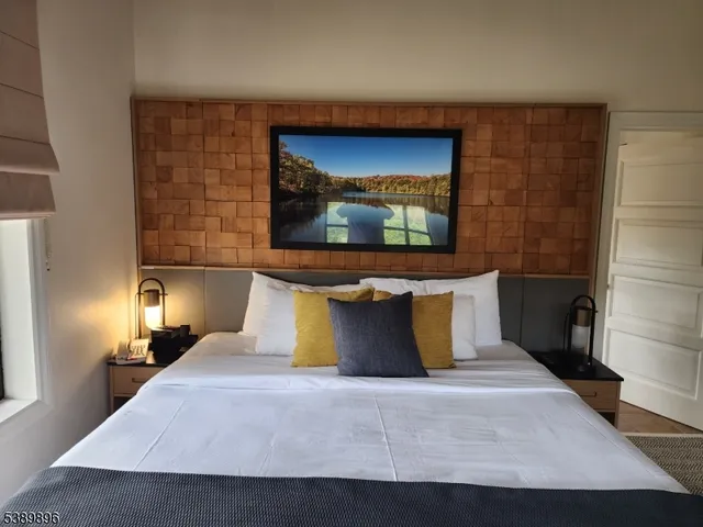a bedroom with a bed and painting on the wall