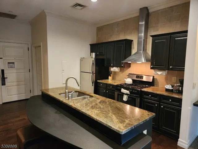a kitchen with granite countertop a sink cabinets and stainless steel appliances