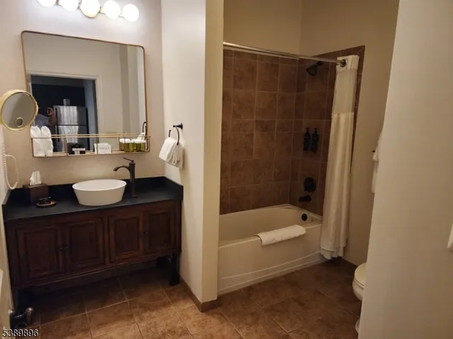 a bathroom with a tub sink and mirror