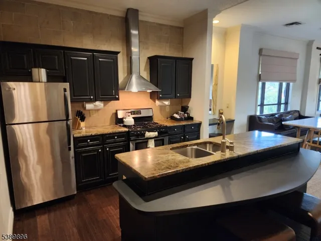 a kitchen with a sink a refrigerator and a stove top oven