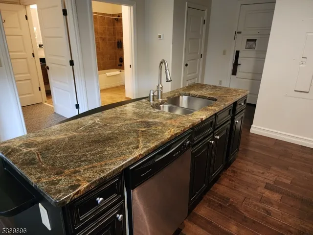 a kitchen with granite countertop sink and cabinets