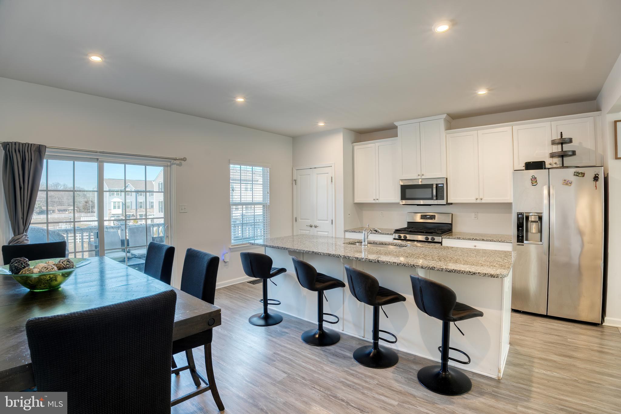 133 Spire Place Sewell, NJ 08080 - Photo 21 of 49 a kitchen with stainless steel appliances a dining table chairs stove refrigerator and cabinets