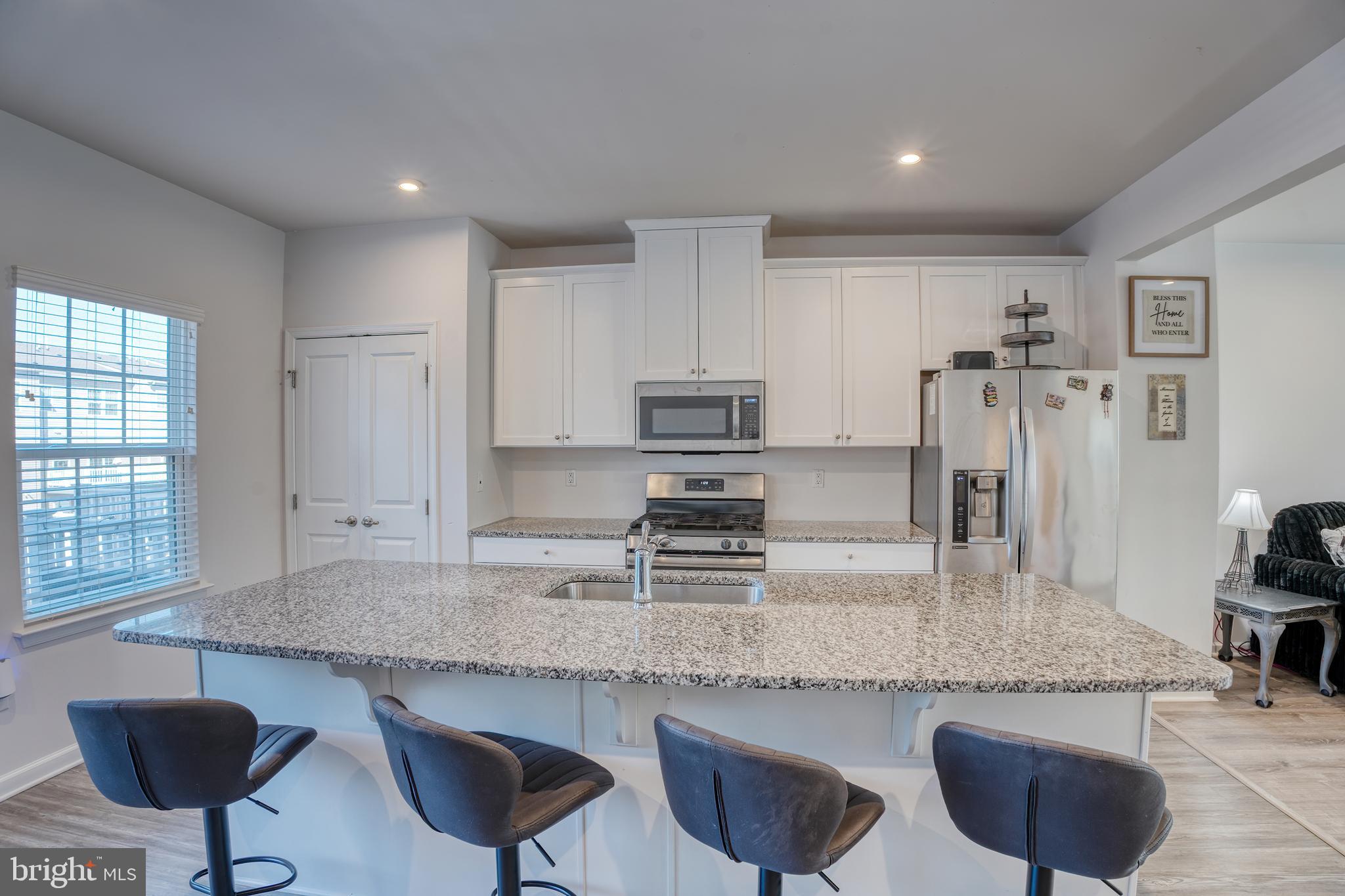 133 Spire Place Sewell, NJ 08080 - Photo 22 of 49 a kitchen with stainless steel appliances granite countertop a stove a sink a microwave a refrigerator and white cabinets