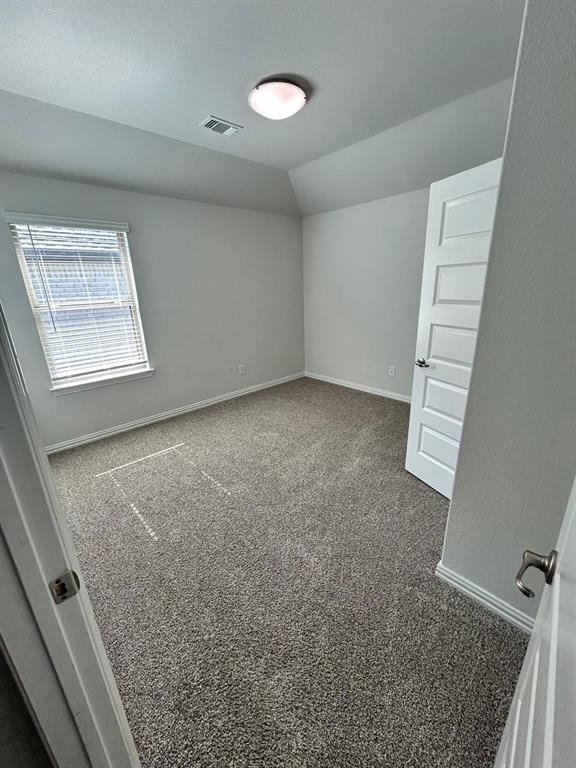 1704 Dunbrook Road McKinney, TX 75071 - Photo 13 of 17 Spare room with carpet floors and lofted ceiling