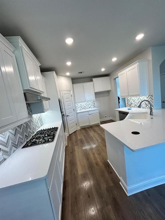 1704 Dunbrook Road McKinney, TX 75071 - Photo 5 of 17 Kitchen with tasteful backsplash, a peninsula, white cabinetry, light stone countertops, and recessed lighting
