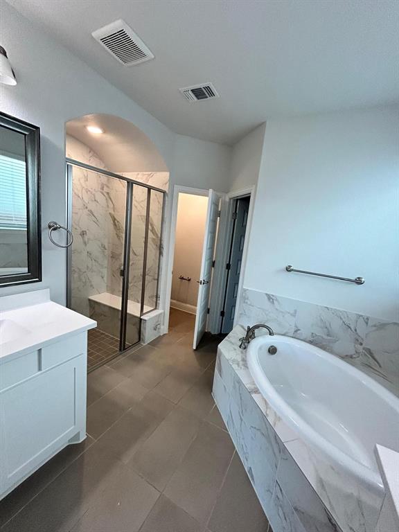 1704 Dunbrook Road McKinney, TX 75071 - Photo 10 of 17 Bathroom with vanity, a bath, a marble finish shower, and dark tile patterned flooring