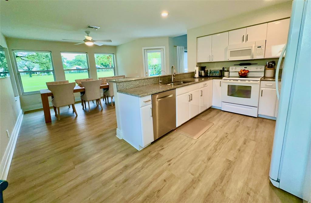 2295 Northwest 53rd Street Boca Raton, FL 33496 - Photo 21 of 89 a kitchen with stainless steel appliances a stove top oven a sink a dining table and chairs