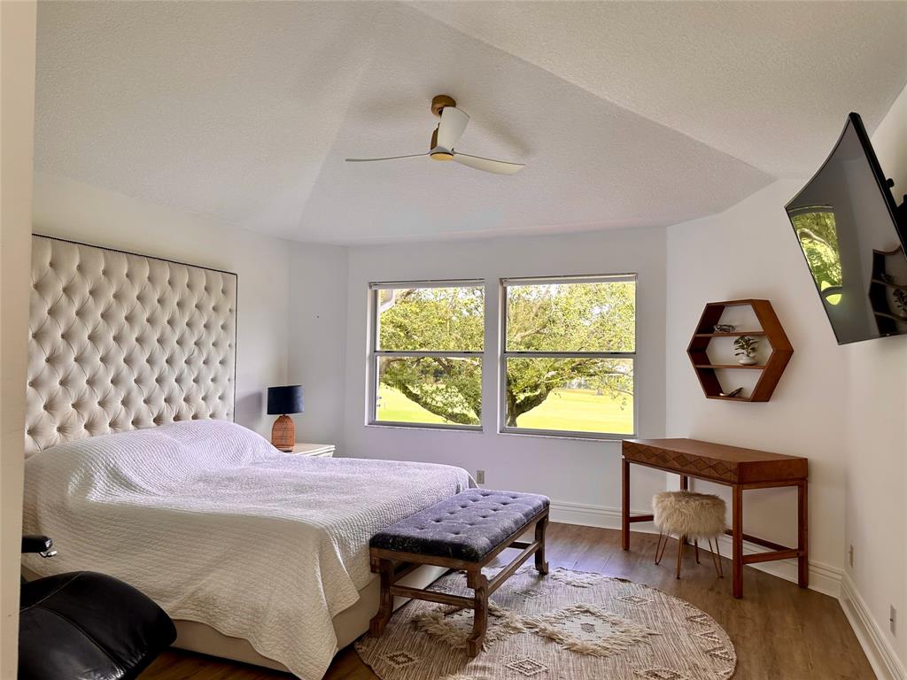 2295 Northwest 53rd Street Boca Raton, FL 33496 - Photo 34 of 89 a bedroom with a bed a clock on wall and a large window