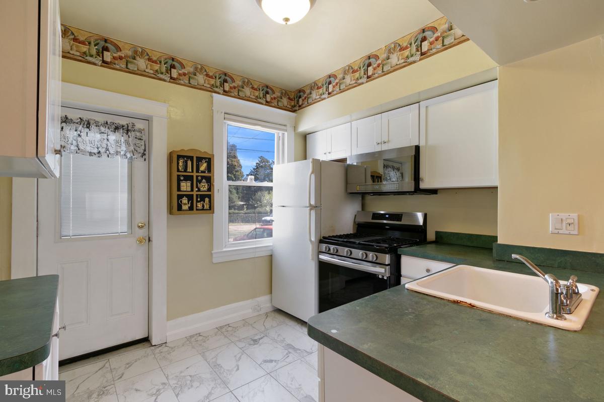 1745 Portship Road Dundalk, MD 21222 - Photo 14 of 44 a kitchen with granite countertop a refrigerator stove and microwave