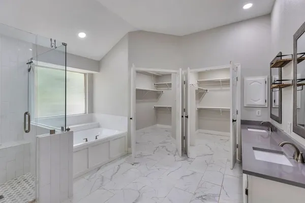 a bathroom with a tub sink shower and mirror