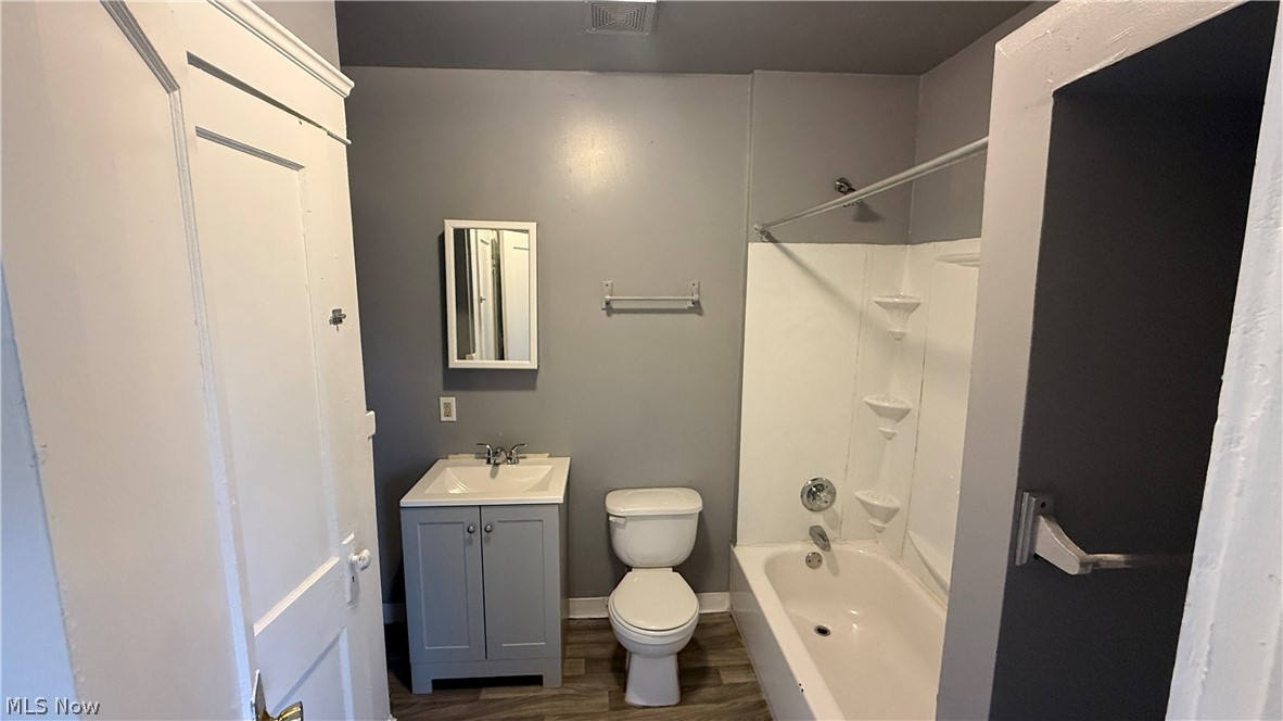 1187 Addison Road, Unit 4 Cleveland, OH 44103 - Photo 15 of 15 Bathroom featuring a white bathtub with integrated shelving, a white toilet, and a vanity with a white sink and gray cabinetry
