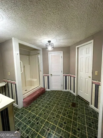 a spacious bathroom with a granite countertop toilet a sink and a large mirror