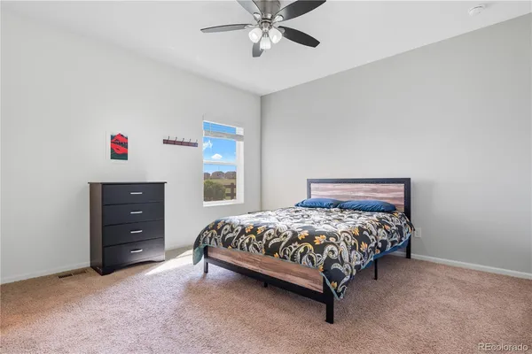a bedroom with a bed and a ceiling fan