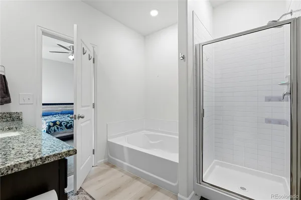 a bathroom with a granite countertop bathtub shower sink and toilet