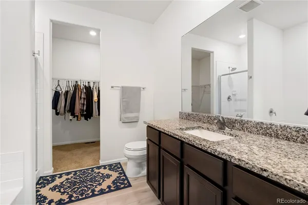 a bathroom with a granite countertop sink toilet and shower