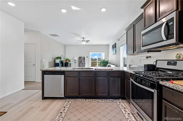 a kitchen with stainless steel appliances granite countertop a stove a sink and a microwave