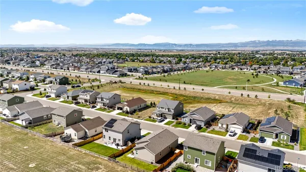 an aerial view of a city with lots of residential buildings and ocean view in back
