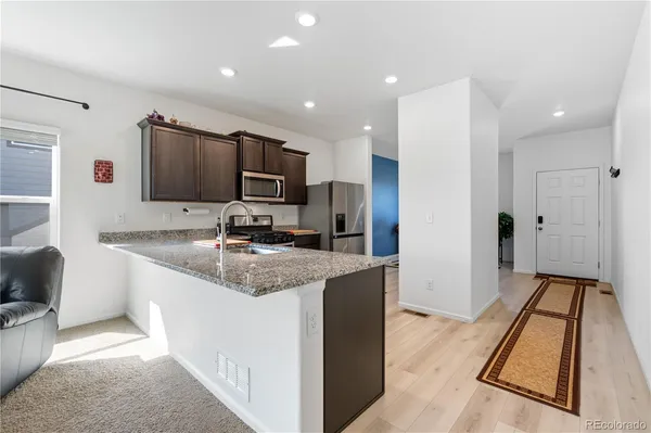 a kitchen with stainless steel appliances granite countertop a sink refrigerator and microwave