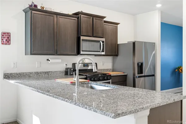 a kitchen with granite countertop a refrigerator and a sink