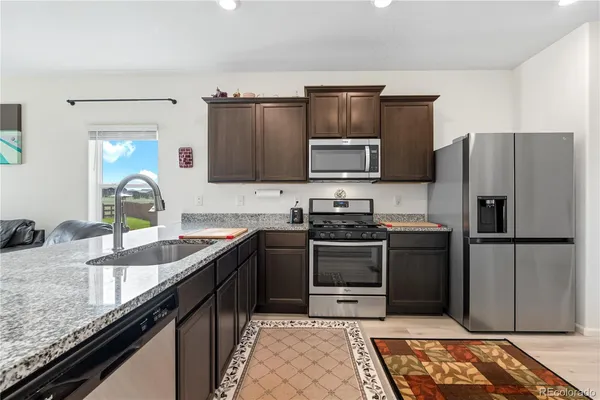 a kitchen with granite countertop stainless steel appliances and wooden cabinets