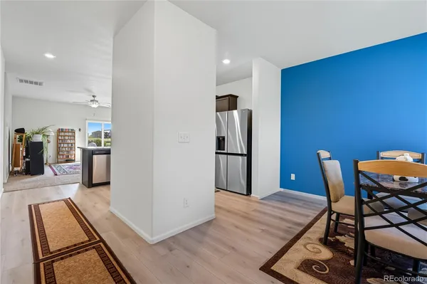 a view of a kitchen with furniture and wooden floor