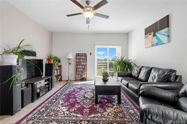 a living room with furniture a flat screen tv and a rug