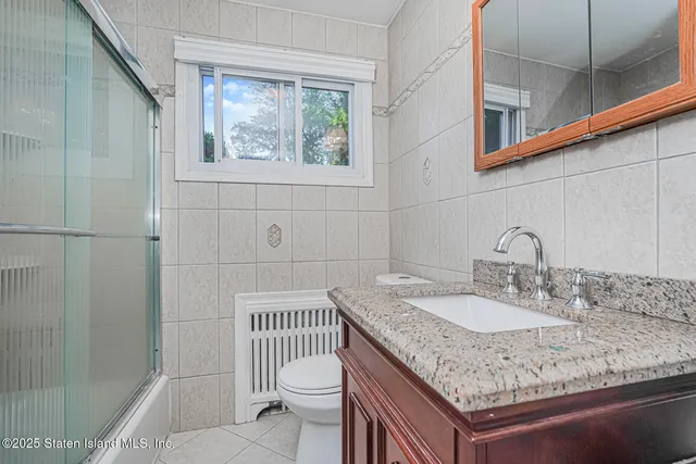 a bathroom with a granite countertop sink a toilet and shower