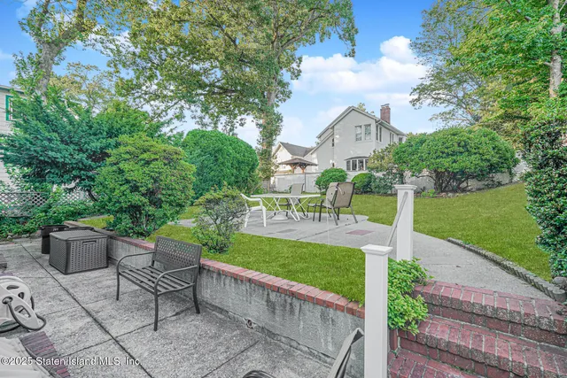 a view of a house with a big yard and large trees