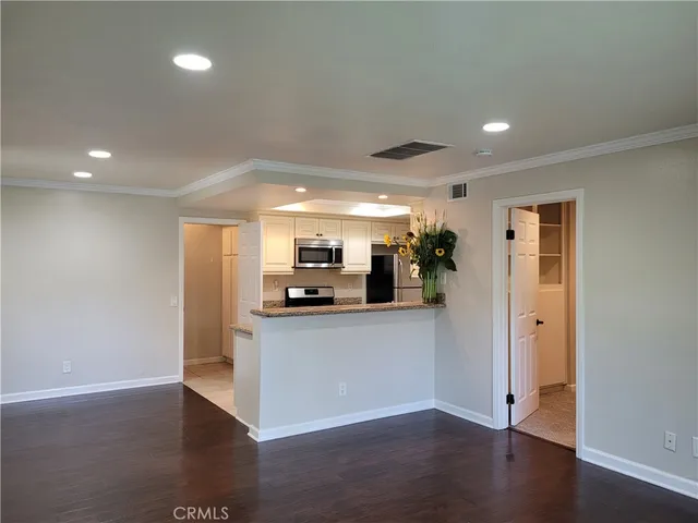 wooden floor in an empty room with a kitchen