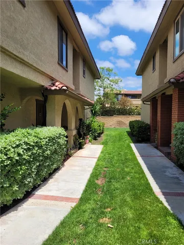 a front view of a house with a yard and potted plants