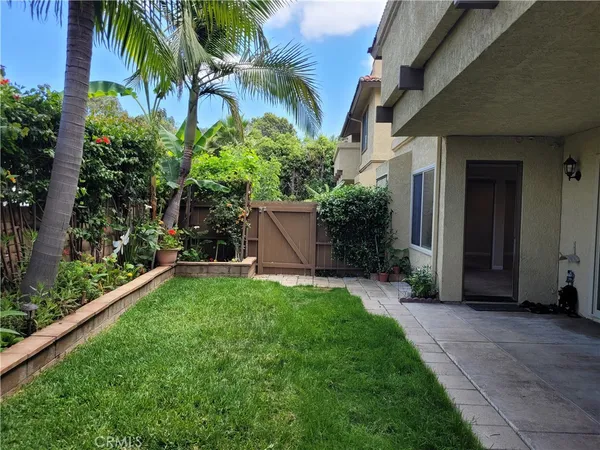 a view of a house with a yard and palm trees