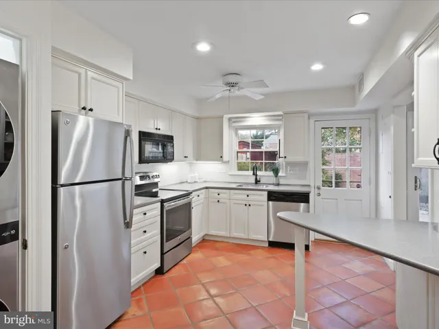 a kitchen with granite countertop stainless steel appliances a refrigerator sink and microwave