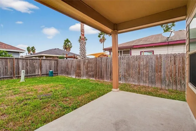 a view of a backyard with wooden fence