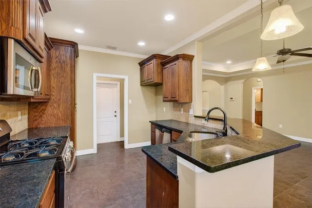 a kitchen with a sink a stove and cabinets